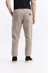 Pantalón de jogging negro de algodón y poliéster, con puños ajustados en los tobillos, cintura elástica con cordón y costuras verticales marcadas en el frente.