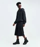 Campera tipo bomber confeccionada en tejido de jean, con cierre frontal de cremallera, capucha ajustable con cordones y bolsillos frontales. Presenta puños y cintura elásticos, ofreciendo un ajuste cómodo y un estilo urbano.