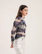 Polera de tul elastizado con cuello alto y mangas largas. Diseño con estampado abstracto en tonos azul, marrón y gris.