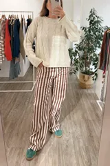 Sweater de tejido de punto con diseño de trenzas verticales, cuello redondo y mangas largas. Presenta un calce holgado y cómodo.