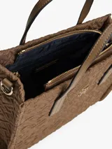 Cartera tipo tote de Tommy Hilfiger, confeccionada en nailon reciclado color marrón con diseño acolchado de monograma TH. Cuenta con dos asas superiores, cierre de cremallera y logo metálico distintivo en la parte frontal.