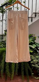 Pantalón de corte piyamero, con cintura ancha elastizada, bolsillos aplicados en la parte trasera y detalles en hilo al tono.