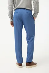 Ambo de vestir color azul, compuesto por saco con solapa en punta y pantalón a juego. El saco cuenta con cierre frontal de dos botones y bolsillos laterales con solapa.