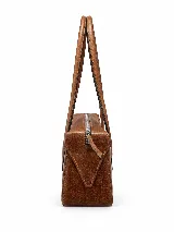 Cartera de cuero tipo baguette, con formato alargado, acabado de efecto vintage, dos asas largas para llevar al hombro y cierre superior.