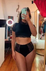 Conjunto de lencería compuesto por un top de cuello alto con mangas cortas y una bombacha de tiro alto. Ambas piezas combinan paneles de terciopelo, microtul transparente y detalles de encaje elastizado.