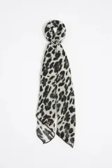 Pañuelo de tela fina color blanco con estampado de manchas de leopardo en negro y marrón.