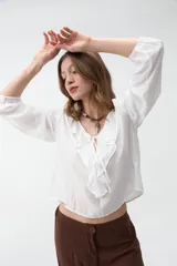 Blusa verde militar de manga larga con volados en el escote en V y lazos para atar al frente.