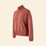 Chaqueta deportiva de color marrón rojizo, con cuello alto tipo camionero y cierre frontal parcial. Presenta mangas largas con puños elásticos, un bolsillo frontal tipo canguro y ruedo con elástico.