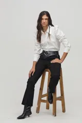 Camisa blanca de popelina de algodón con cuello camisero clásico, hombros abullonados, mangas largas y botones de nácar en el frente.