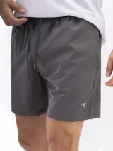 Short de baño de secado rápido, con cintura elástica y cordón ajustable. La parte superior es de color verde agua con un estampado de motivos circulares en tono azul oscuro. La parte inferior es de color terracota con un patrón de microperforaciones.