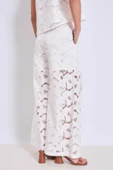 Pantalón palazzo blanco de broderie con cintura alta y pierna ancha.