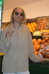 Canguro beige de tejido waffle con capucha, mangas largas y cierre parcial con botones.