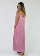 Vestido largo sin mangas de color marrón con efecto gastado, tirantes finos, escote en V con volados y gran volante central delantero que recorre toda la prenda. Cuenta con bolsillos laterales.