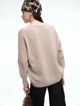 Cardigan de punto color marrón con textura jaspeada, escote en V, cierre frontal con botones y diseño de hombros caídos.