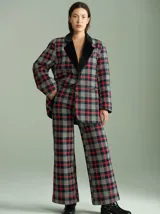 Pantalón de tiro alto con corte ancho y recto, confeccionado en tela de algodón con estampado de cuadros escoceses en tonos azul marino, verde y rojo. Presenta cierre frontal oculto con botones internos y pasacintos en la cintura.