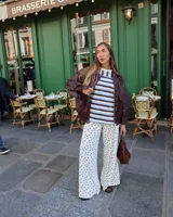 Remera de corte oversize con estampado de rayas horizontales en tonos marrón, celeste y blanco. Presenta mangas cortas con detalles de encaje tipo broderie en color crema.