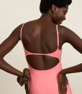 Vestido deportivo color rosado, ajustado al cuerpo, con breteles finos ajustables y gran abertura en la espalda. Incluye short interno.