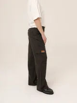 Pantalón cargo de corte recto y tiro alto, color beige con estampado de rayas verticales finas. Presenta bolsillos laterales tipo cargo con solapa y parche de cuero con logo de la marca.
