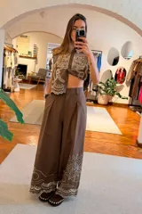 Pantalon de pierna ancha y tiro alto color marron, con bordado en contraste que recorre el ruedo y detalles en calado.