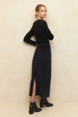 Maxifalda de pana de tiro alto, con cierre frontal, botón metálico, cuatro bolsillos y abertura trasera.