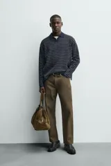Pantalón de corte recto confeccionado en denim de algodón rígido con efecto lavado. Presenta tiro medio, cierre frontal con cremallera y botón, y diseño clásico de cinco bolsillos.