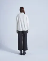 Sweater de lana color crema con cuello alto y mangas largas. Posee detalles calados en la parte superior del pecho y diseño acanalado en puños y ruedo.