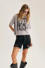 Short de denim negro de tiro alto, con roturas y flecos en el ruedo.
