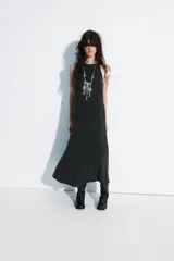 Vestido midi fluido de mezcla de viscosa en color bordó, con cuello redondo, manga sisa y detalle de lazada con abertura en la espalda.