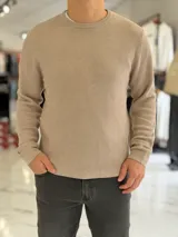 Buzo de hilo gris oscuro con diseño de tejido acanalado, cuello redondo y mangas largas.