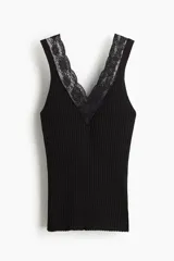 Musculosa entallada de punto acanalado, color negro, con breteles anchos y escote en V profundo decorado con ribete de encaje.