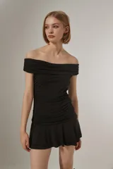 Vestido corto azul marino con escote strapless, diseño al cuerpo con frunces en el torso y falda con volados en el ruedo.