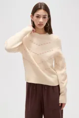 Sweater de punto color azul con diseño de fantasía en forma de líneas curvas punteadas en color celeste. Presenta cuello redondo a la base, mangas largas con puños acanalados y corte holgado.