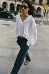 Camisa verde militar confeccionada en mezcla de lino, con cuello solapa, escote en pico, manga larga y diseño asimétrico con pliegues en la parte delantera.