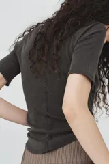 Camiseta de algodón color terracota con efecto lavado, cuello redondo y manga corta. Posee un bajo redondeado.