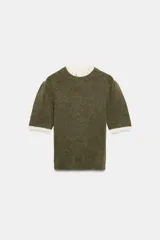 Jersey de punto color verde oliva con cuello redondo y mangas cortas. Presenta detalles de terminaciones en tejido pointelle de color crema en el cuello y los puños.