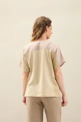 Blusa de lino de diseño contemporáneo, con escote cuadrado y mangas cortas en recortes que combinan distintas texturas. Su propuesta incorpora una franja vertical en contraste que aporta dinamismo y personalidad, mientras que el calce relajado la convierte en una prenda fresca y versátil.