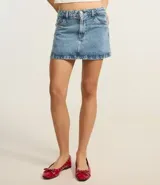 Pollera mini de jean color negro, con cintura mediana, trabillas para cinturón, bolsillos laterales y cierre frontal con botón y cremallera.