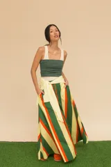 Pollera larga de cintura alta con rayas verticales marrones, negras y verdes. Confeccionada en algodón, con bolsillos laterales y corte evasé.