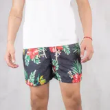 Short de baño negro con estampado de flores rojas y hojas verdes.