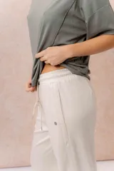 Pantalón gris melange de calce relajado y pierna amplia, con cintura elastizada y cordón regulable. Cuenta con bolsillos laterales y tejido de tacto suave.