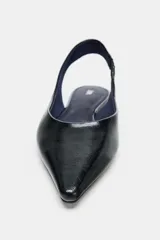 Zapato plano tipo bailarina destalonada en color negro, con acabado brillante, escote redondo y punta fina.