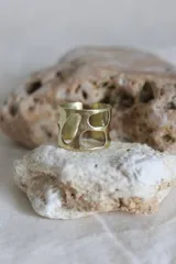 Anillo ancho de bronce con diseño calado irregular.