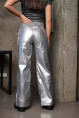 Pantalón plateado metalizado elastizado de ecocuero, con corte recto, tiro alto, cierre frontal con botón y bolsillos traseros.