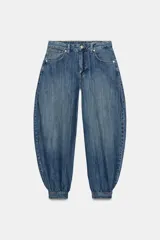 Jeans de tiro medio y diseño balloon, color azul denim con efecto lavado, cinco bolsillos, cierre frontal con cremallera y botón metálico, y bajos acabados en puño.