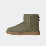 Botas de caña baja UGG, color negro, confeccionadas en piel de oveja con forro interior de lana suave y suela de goma resistente.