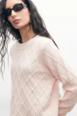 Sweater rosa pastel de tejido de punto con estructura en forma de rombos y apliques de perlas.