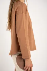 Sweater color marrón claro con textura tipo waffle, corte holgado y mangas largas.