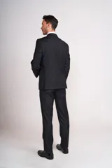 Traje de dos piezas compuesto por saco de corte clásico con cierre de un botón y pantalón de vestir a juego. Presenta solapas de muesca y bolsillos con solapa.