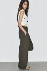 Pantalón de tiro medio con pierna ancha, confeccionado en tejido lavado. Presenta cintura elástica ajustable con cordones, bolsillos laterales y bolsillos traseros decorados con estrellas y aplicaciones de tachas. El diseño cuenta con terminaciones desflecadas en el ruedo.