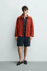 Sobrecamisa de algodón color rojo con efecto lavado, corte regular fit, cuello solapa, cierre frontal de botones, bolsillo en el pecho y bolsillos frontales de plastrón.